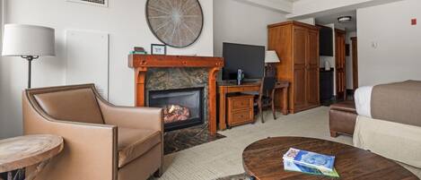 Una sala de estar con chimenea, un sofá, una mesa de centro y un televisor.