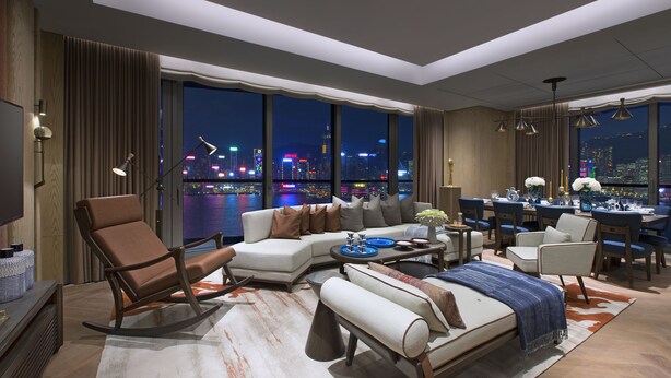 Une chambre d’hôtel moderne offrant une vue imprenable sur la ville, avec un canapé, un coin repas et un lit.