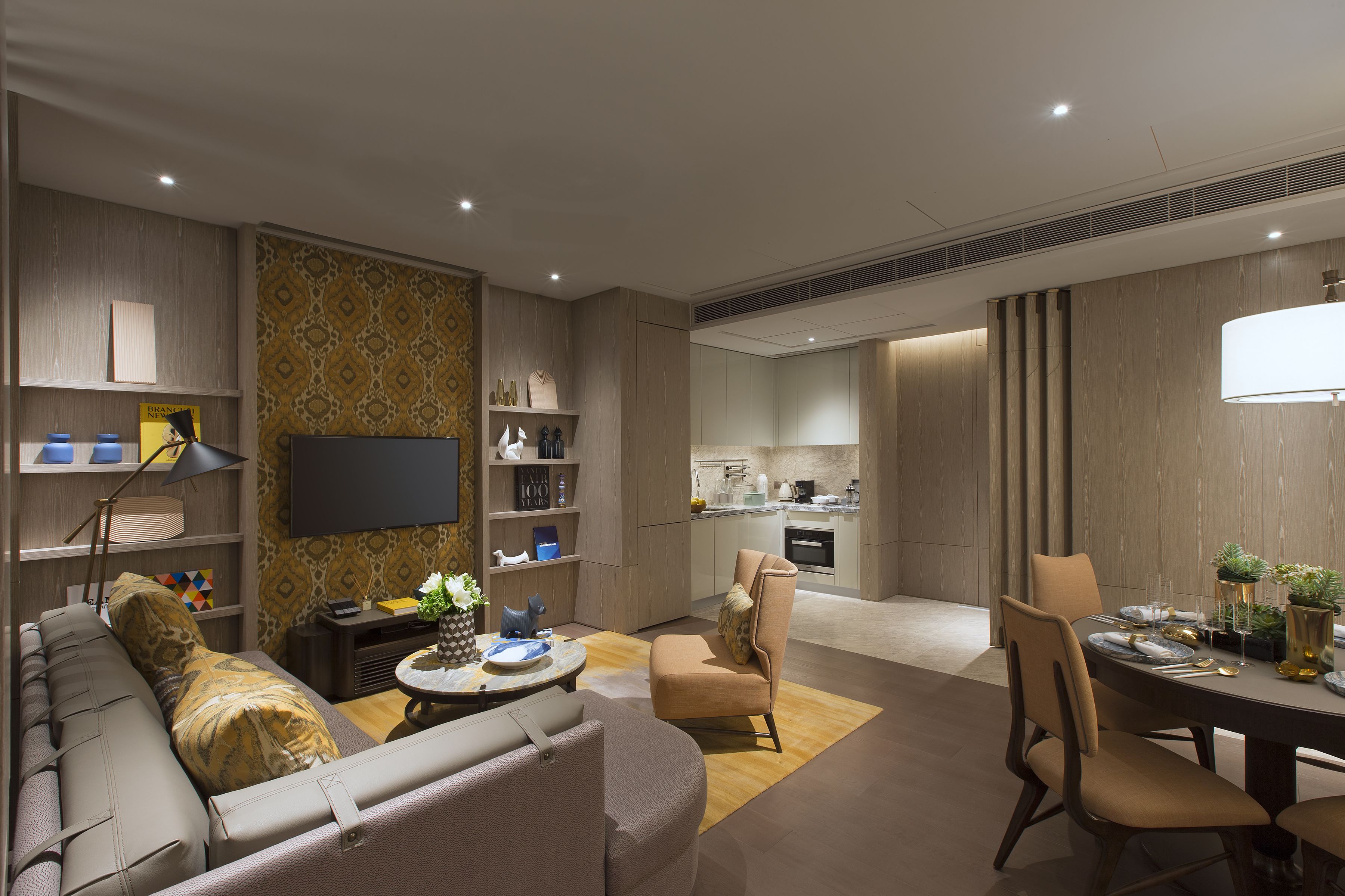 A modern living room with a sofa, armchairs, a dining table set for four, and a kitchen in the background.