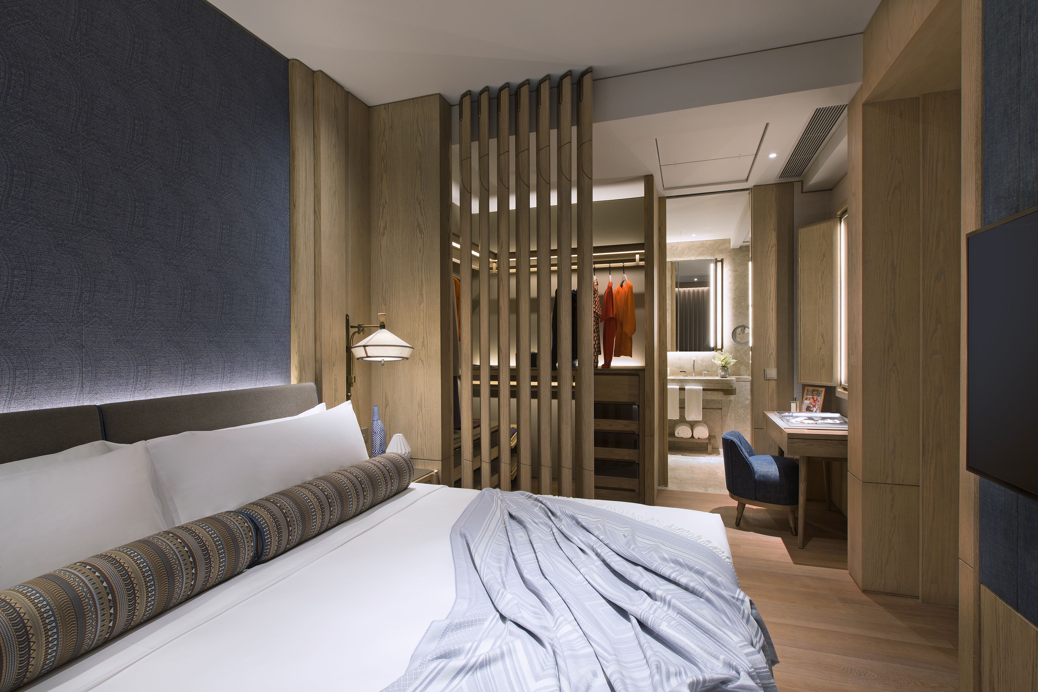 Una habitación de hotel moderna con una cama grande, un escritorio y un armario.