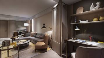 A modern living room with a sofa, coffee table, and a desk with a lamp and books.