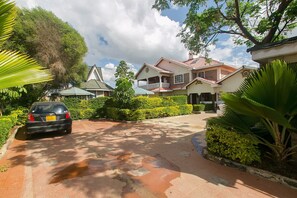 Stroll through the serene surroundings of this traditional two-story house, set amidst lush greenery and trees.