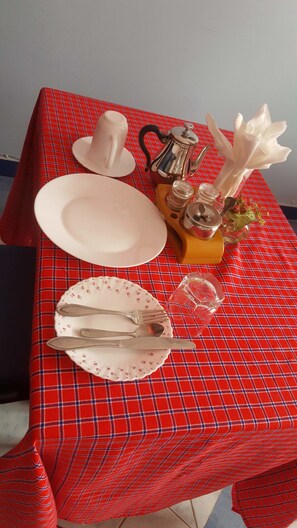 A beautifully set table with a teapot, sugar bowl, and vase with white flowers.