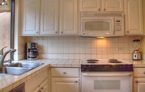 Efficient kitchen with a stainless steel sink, coffee maker, and modern stove.