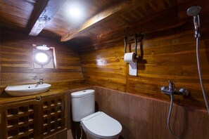 A wooden cabin bathroom with a sink, toilet, and shower. - Helena Liveaboard (Labuan Bajo)