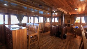 L’intérieur d’un chalet en bois comprend un coin repas, un bar et de grandes fenêtres.
