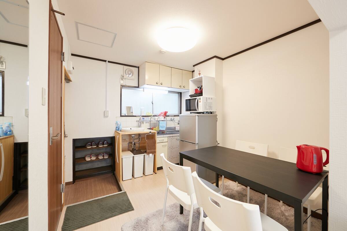 A compact kitchen with a dining area, including a microwave, refrigerator, and a small sink.
