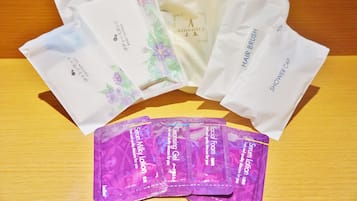 En träyta med olika produkter för personlig hygien, inklusive en hårborste, ett duschschampo och flera förpackningar ansiktsrengöring och rengöringsgel.