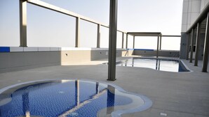 Piscina exterior con solárium azulejado y superficie de agua cristalina.