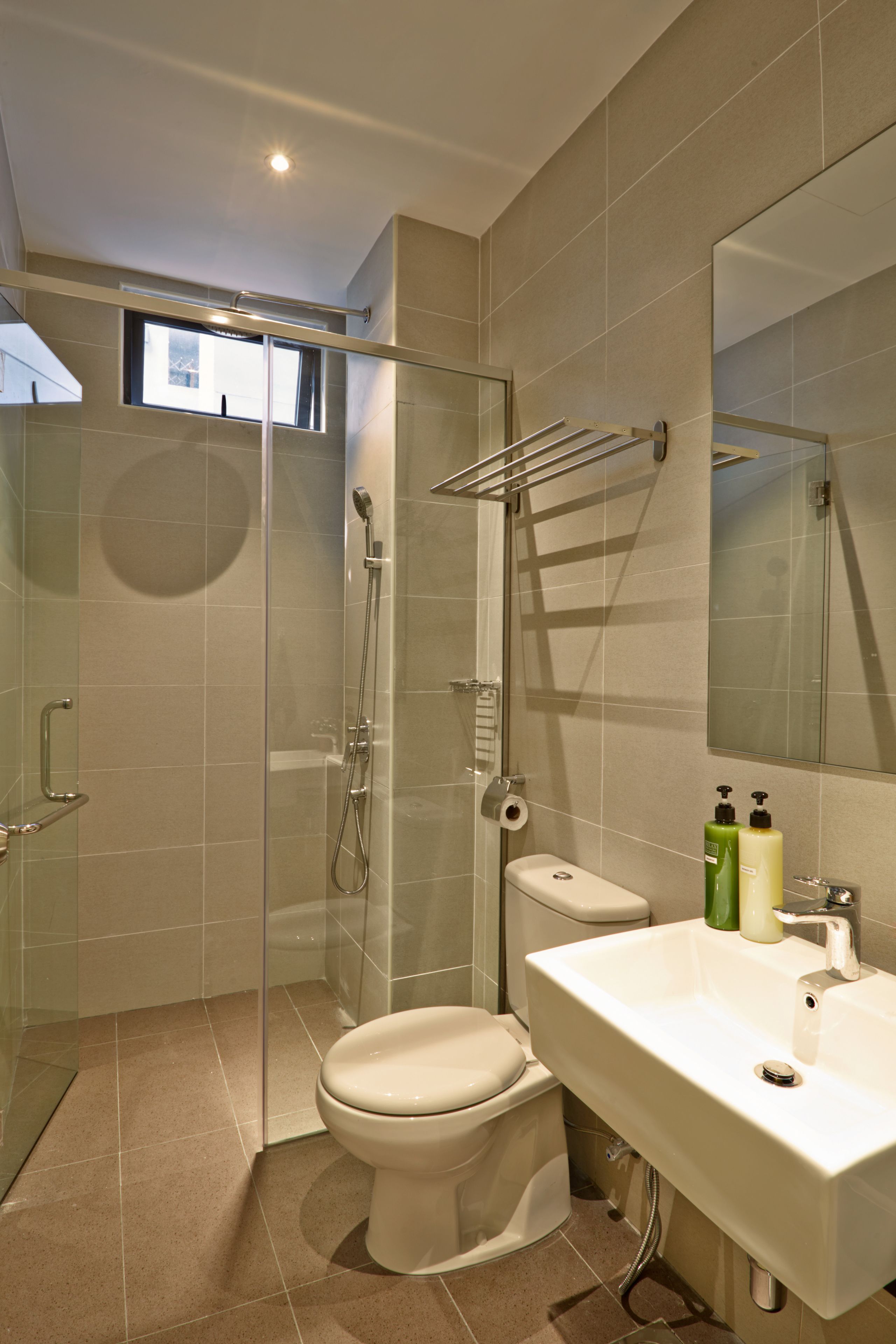 Un baño moderno con ducha acristalada, inodoro y lavamanos.