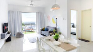 A modern living room with a dining area, a sofa, and a TV. - A5 FAMILY Suites 4-6pax-Atlantis-Smart TV-Melaka-WIFI (Malacca City)