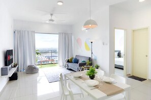 Relax in this stylish living space with a city view, featuring a sofa, flat-screen TV, and dining area.