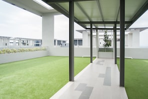 Relax in a spacious open-plan area with a green artificial turf surface and large windows.