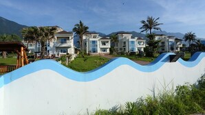 A row of modern, multi-story residential buildings with a wavy blue and white wall in the foreground. - Taroko Bay B&B (Xincheng)