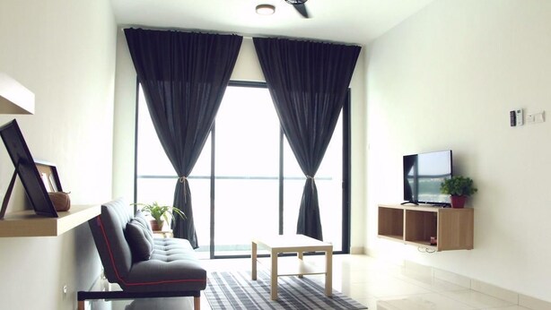 Uma sala de estar moderna com sofá, mesa de centro, TV sobre suporte de madeira e janelas amplas com cortinas.