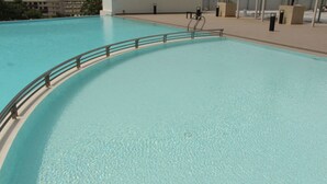 Uma piscina interior ampla e translúcida, com borda curva e grade de metal.