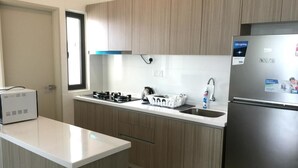 Uma cozinha moderna com arm ários de madeira, geladeira de aço inoxidável e forno embutido.