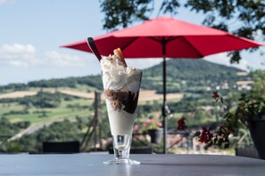 A dessert on a table with a red umbrella in the background.