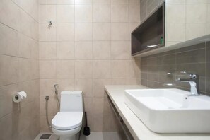 A bathroom with a toilet, sink, and shower.