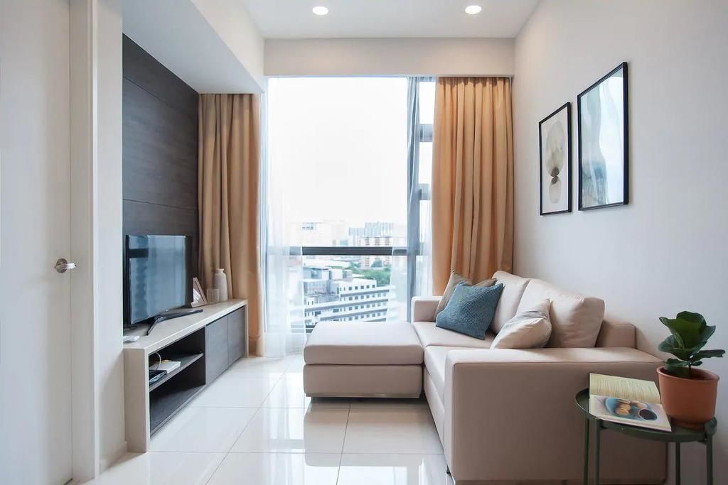 A modern living room with a sofa, a television, and a potted plant.