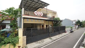 A two-story building with a balcony and a sign that reads "OYO". - OYO 302 Karolin Homestay (Malang)