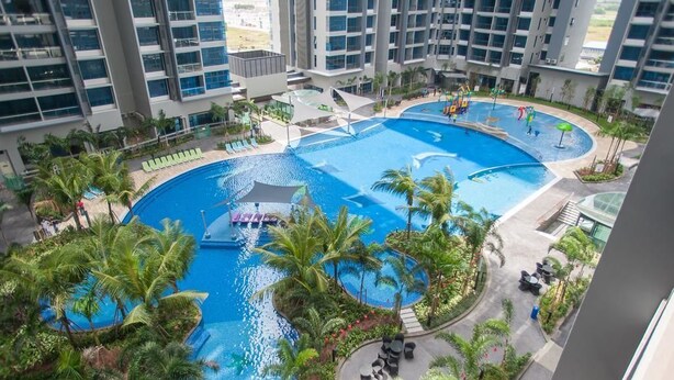 A large indoor swimming pool with multiple sections, surrounded by palm trees and lounge areas. - A4 COZY Atlantis Family Suites 4-6pax-Pool View-Jonker (Malacca City)