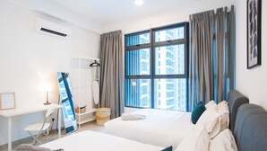 A hotel room with two beds, a desk, a chair, a mirror, and a large window with curtains. - A4 COZY Atlantis Family Suites 4-6pax-Pool View-Jonker (Malacca City)
