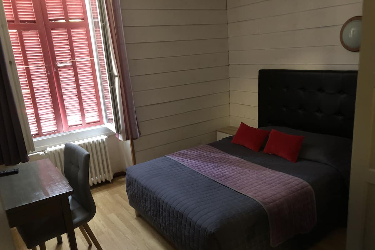 Una camera da letto con un letto, una scrivania e una sedia.