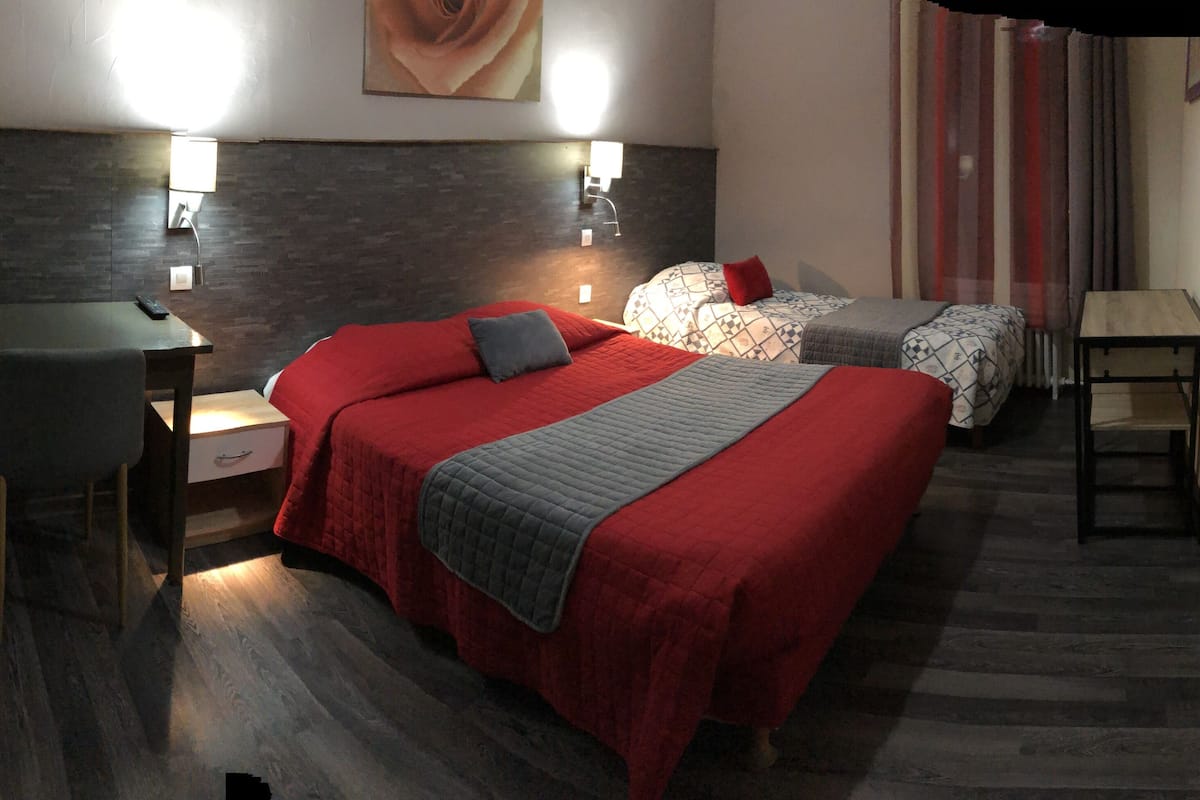 Una camera d'albergo con un letto grande, una scrivania e due lampade ai comodini.