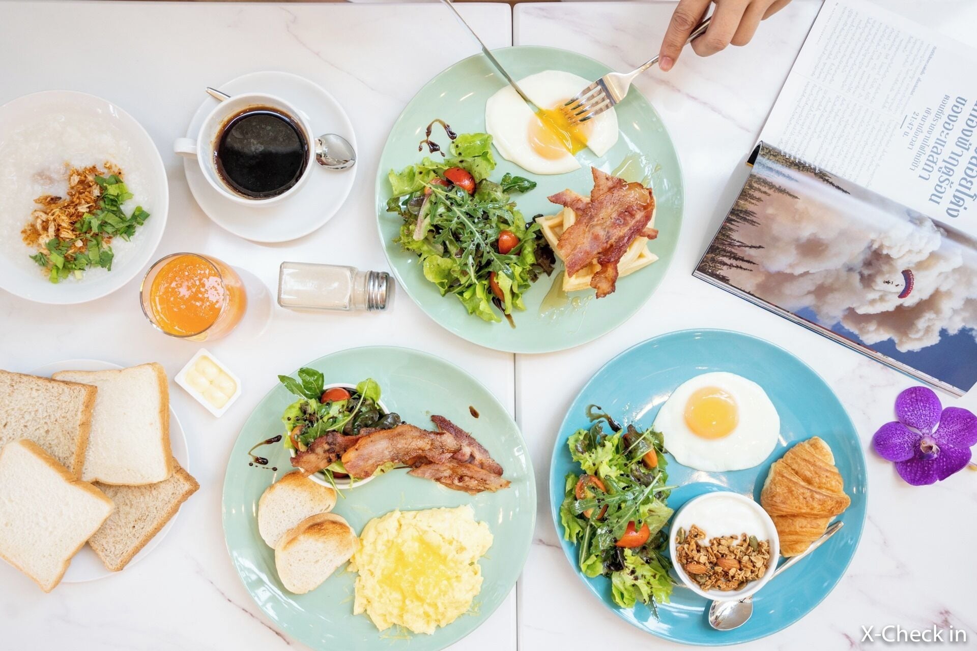A breakfast setting with various dishes including eggs, bacon, toast, and a salad.