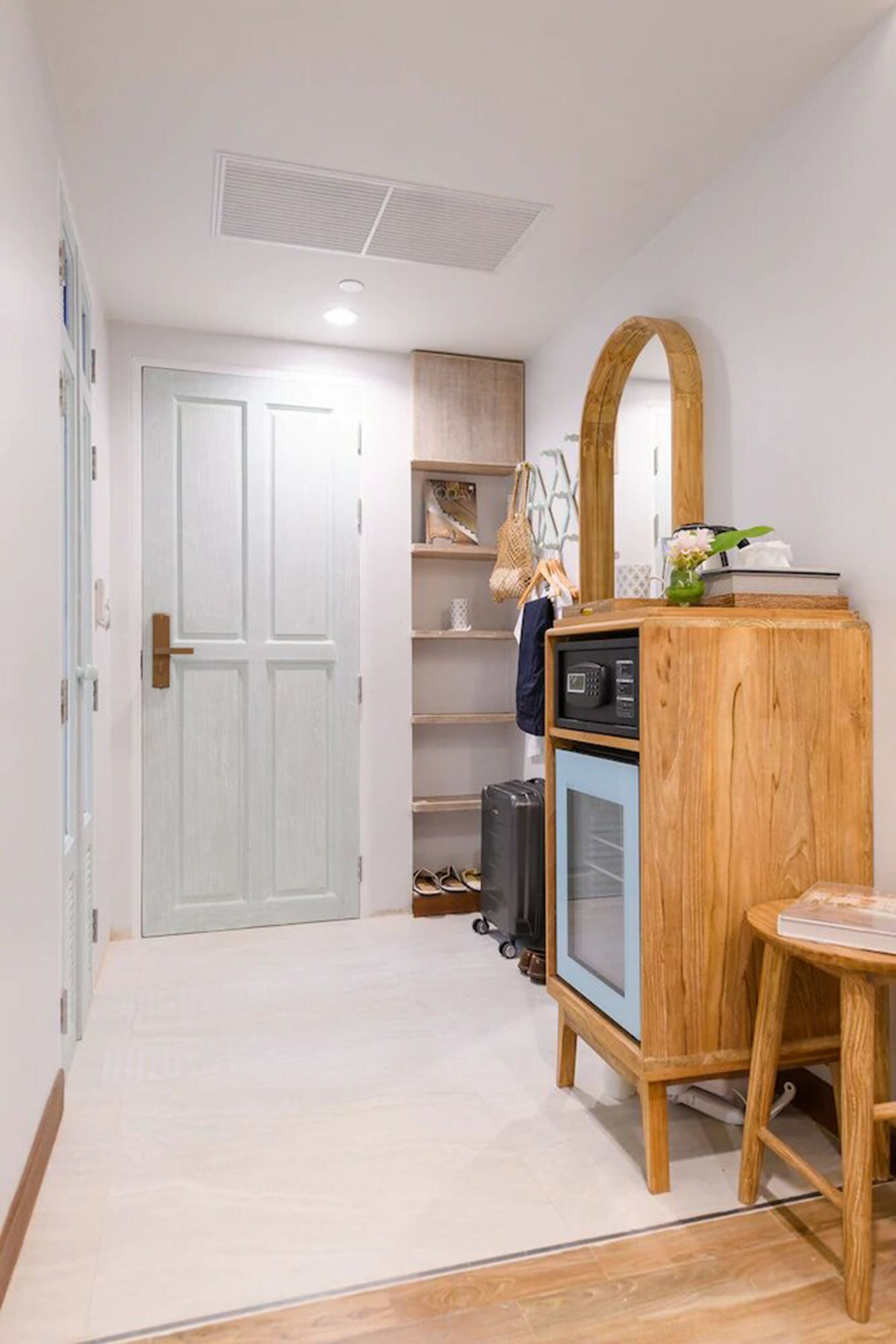 A hallway with a wooden cabinet, a microwave, and a small table.
