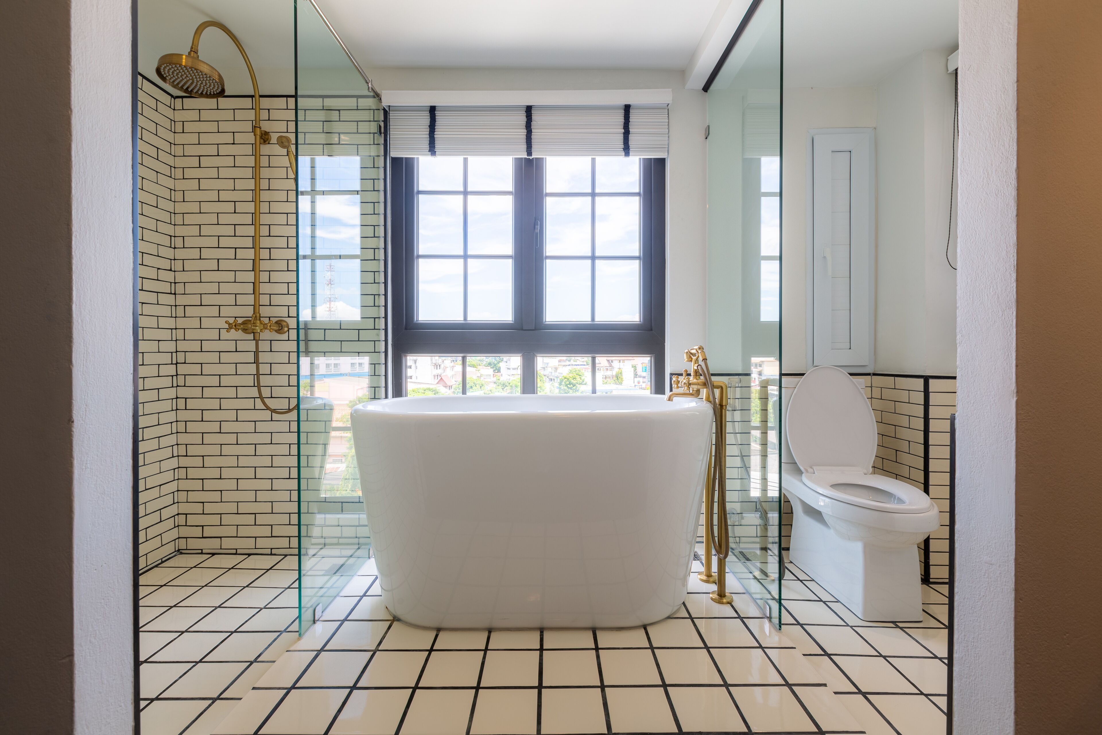 A modern bathroom with a freestanding bathtub, a glass-enclosed shower, and a toilet.