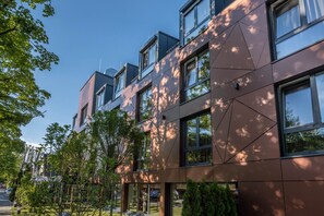 A modern building with multiple floors, large windows, and a mix of glass and metal facade.