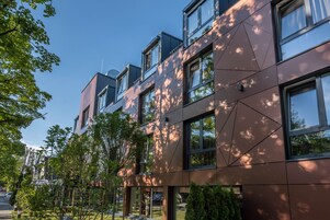 Un edificio moderno con diversi piani, ampie finestre e una facciata in vetro e metallo.