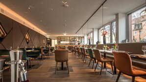 Ein modernes Restaurant mit einer langen Theke, mehreren Tischen und Stühlen.