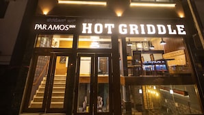 A building with a sign reading "HOT GRIDDLE" and "PAR AMOS INN" at the entrance. - Hotel Paramos Inn (Bengaluru)