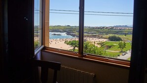 Ein Zimmer mit einem großen Fenster mit Blick auf Strand und Park.
