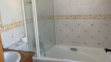 A bathroom with a toilet, sink, and bathtub.