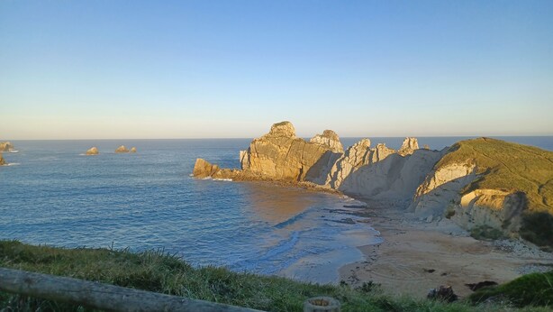 A coastal landscape with rocky cliffs and a sandy beach. - La Venta Del Mar (Pielagos)