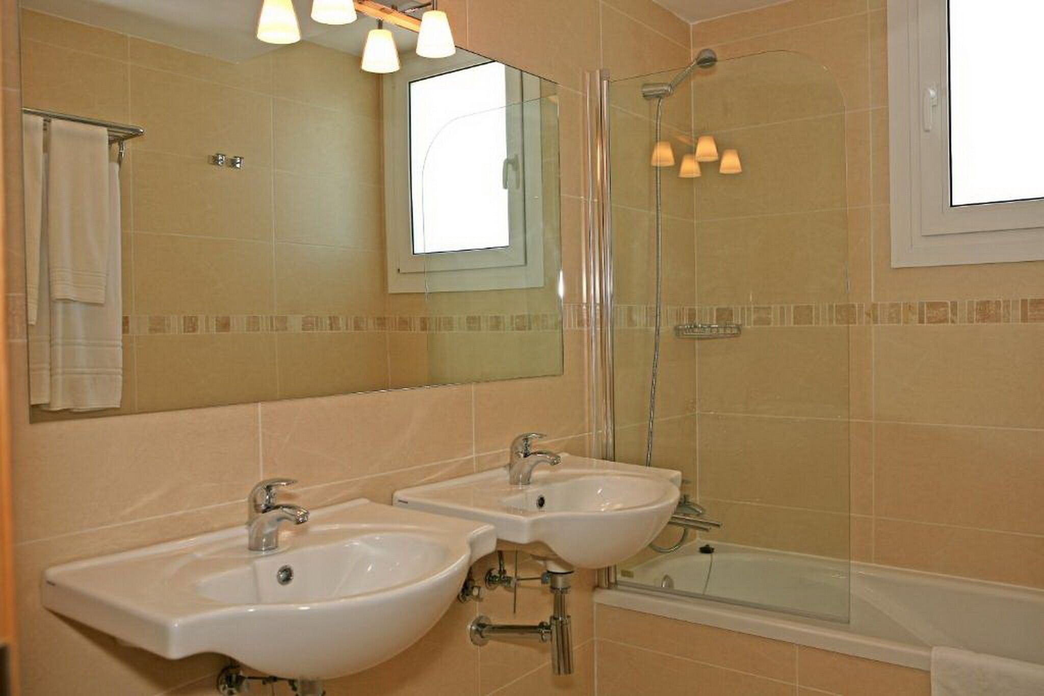 Une salle de bain avec deux lavabos, une douche et une baignoire.