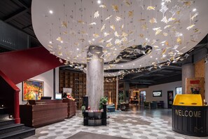 A modern lobby with a checkered floor, a reception desk, and a 'WELCOME' sign. - Moju Hotel Shanghai (Shanghai)