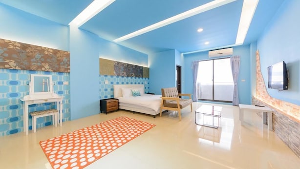 A modern bedroom with a bed, a chair, a desk, and a TV. - Cat Mia Hostel (Hualien City)