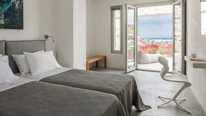 A hotel room with two beds, a bench, a white chair, and a view of the sea through open doors. - Villa Artemis By Mykonos Luxury (Mykonos)