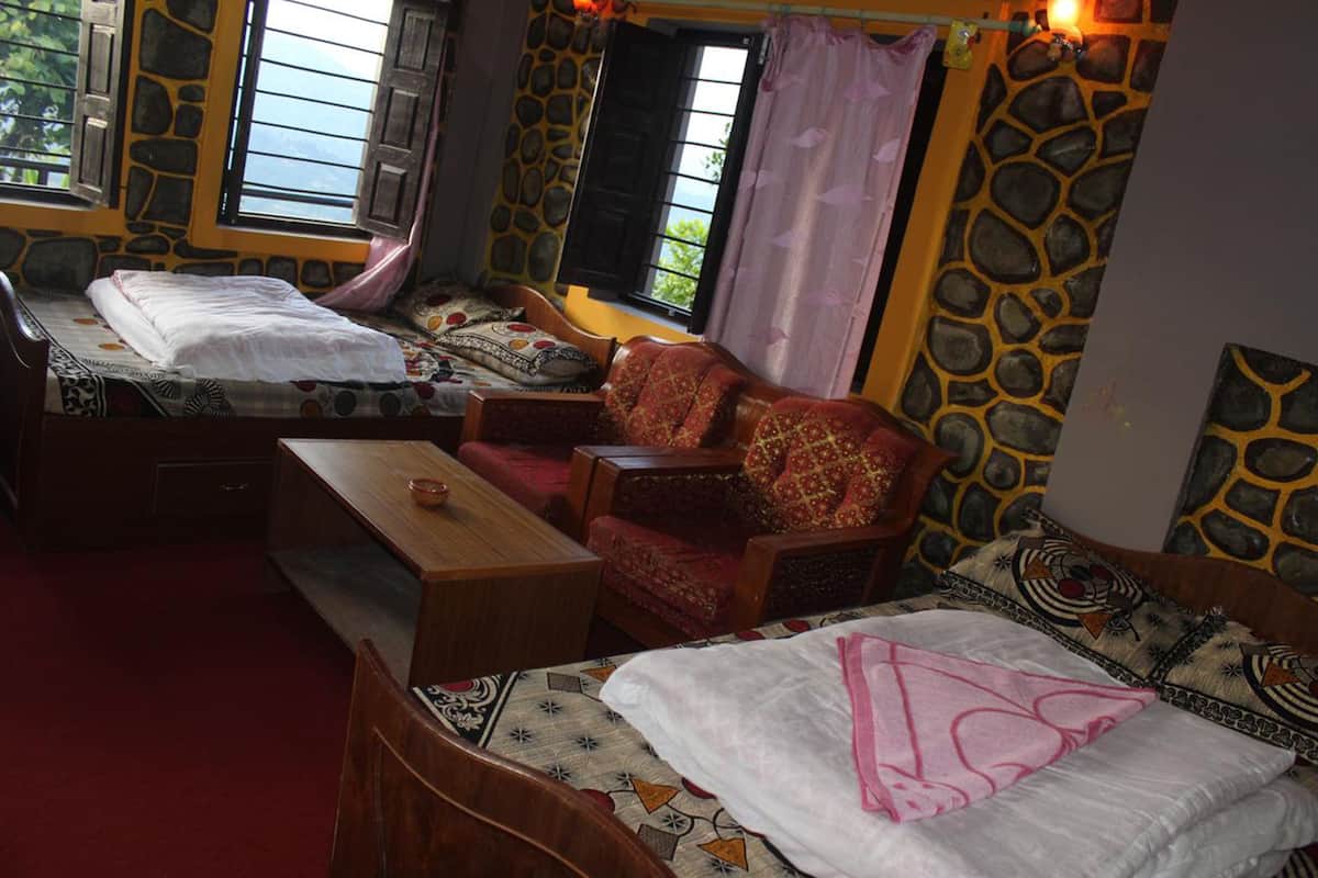 A cozy room with two beds, a sofa, and a wooden table.