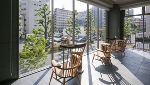 Habitación de hotel moderna con amplios ventanales que ofrecen vista a la ciudad y vehículos estacionados.