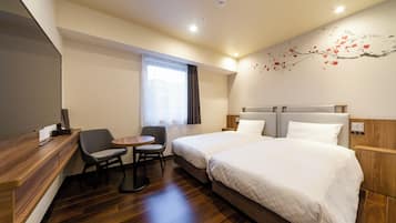A hotel room with two beds, a desk, a chair, a TV, and a window with curtains.