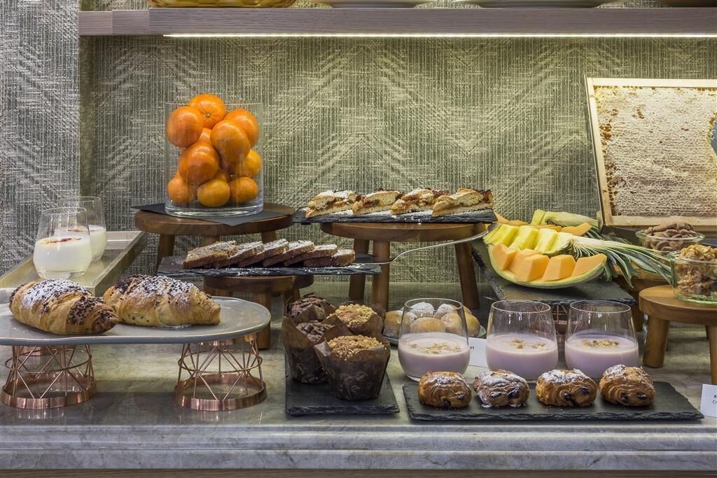 Un bufé con diversas bollerías, frutas y bebidas.
