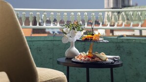 Une table avec de la nourriture et des fleurs sur un balcon donnant sur un immeuble.