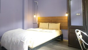 Un dormitorio con cama, cabecero de madera y una puerta con espejo.