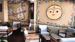Un restaurante con mobiliario de madera y murales coloridos en las paredes.
